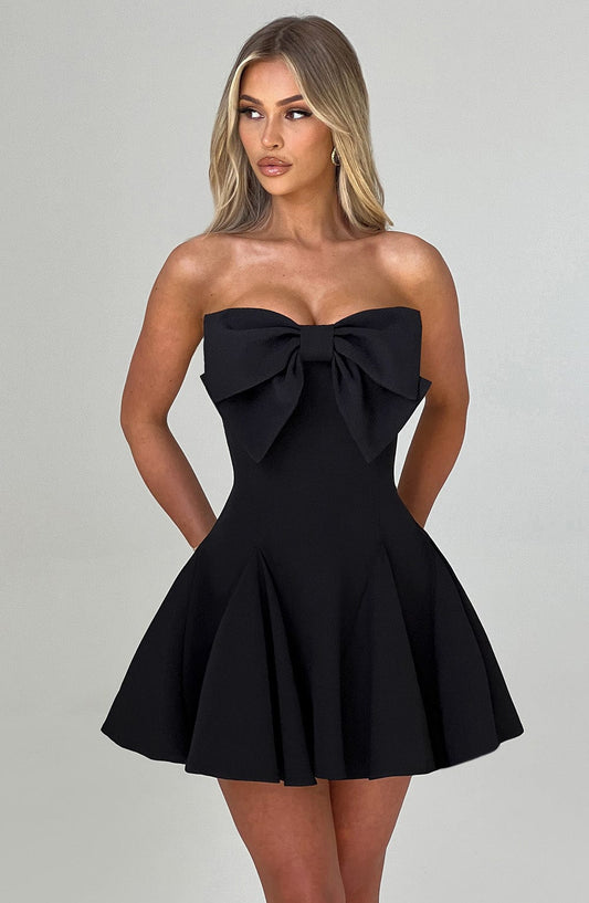 Black strapless dress with a large bow detail on a gray background