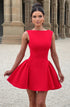 Woman wearing a red dress standing in front of classical architecture.
