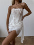 White lace dress worn by a model against a neutral background