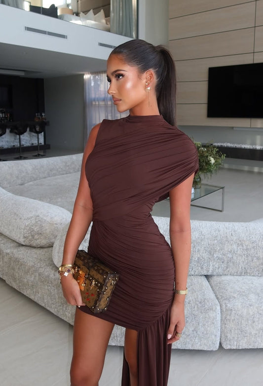 Woman in a brown dress standing in a modern living room.