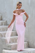 Woman in a pink evening gown standing on stone steps against a gray wall.