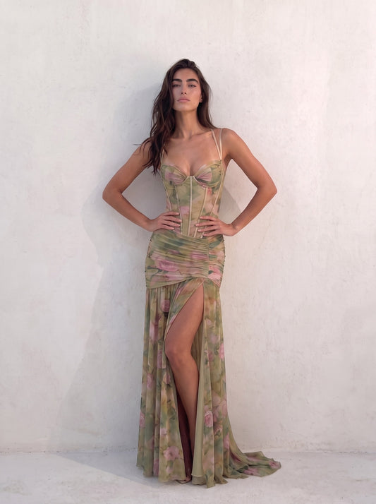 Woman in a sage green floral corset gown with hands on hips and the thigh-high split open — SÉRAPHINE CORSET GOWN — Kalii