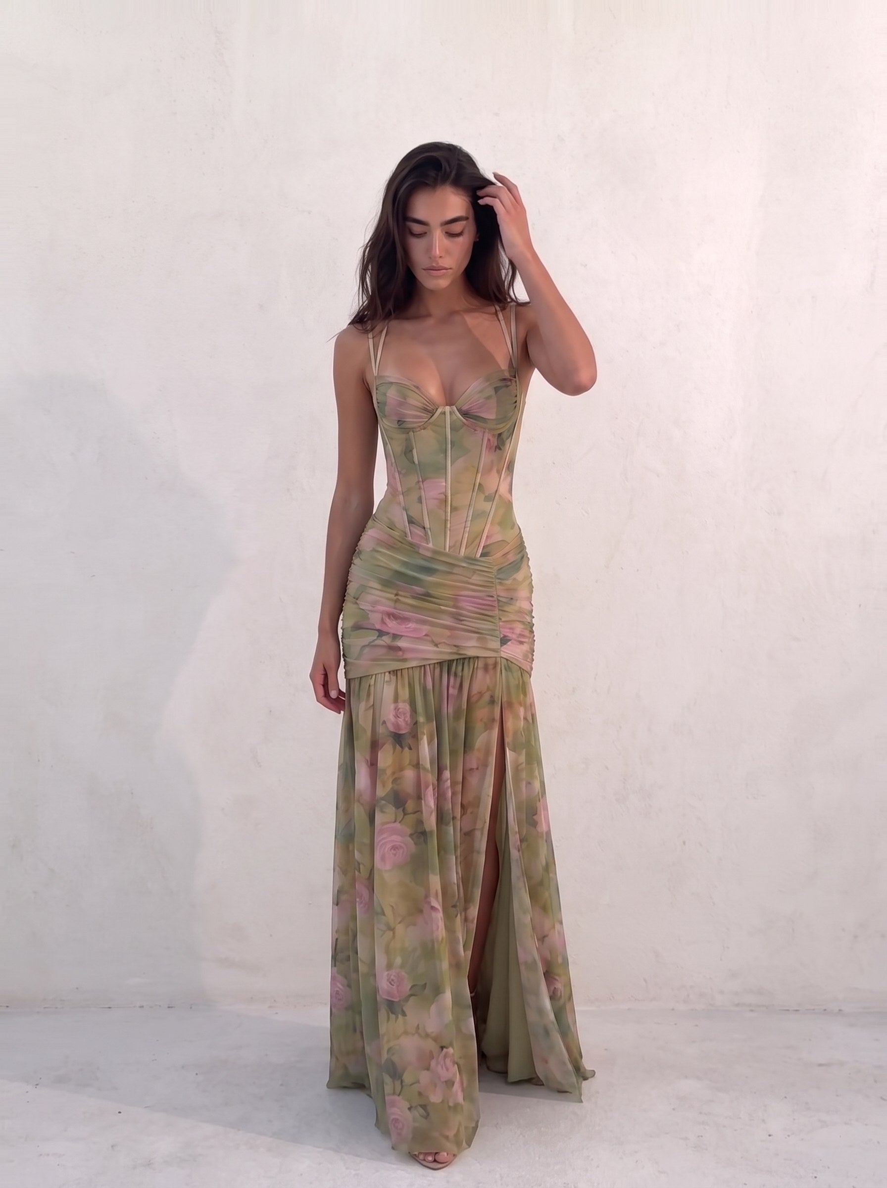 Woman walking in a sage green floral mesh gown, hand in her hair, thigh split open — SÉRAPHINE CORSET GOWN — Kalii