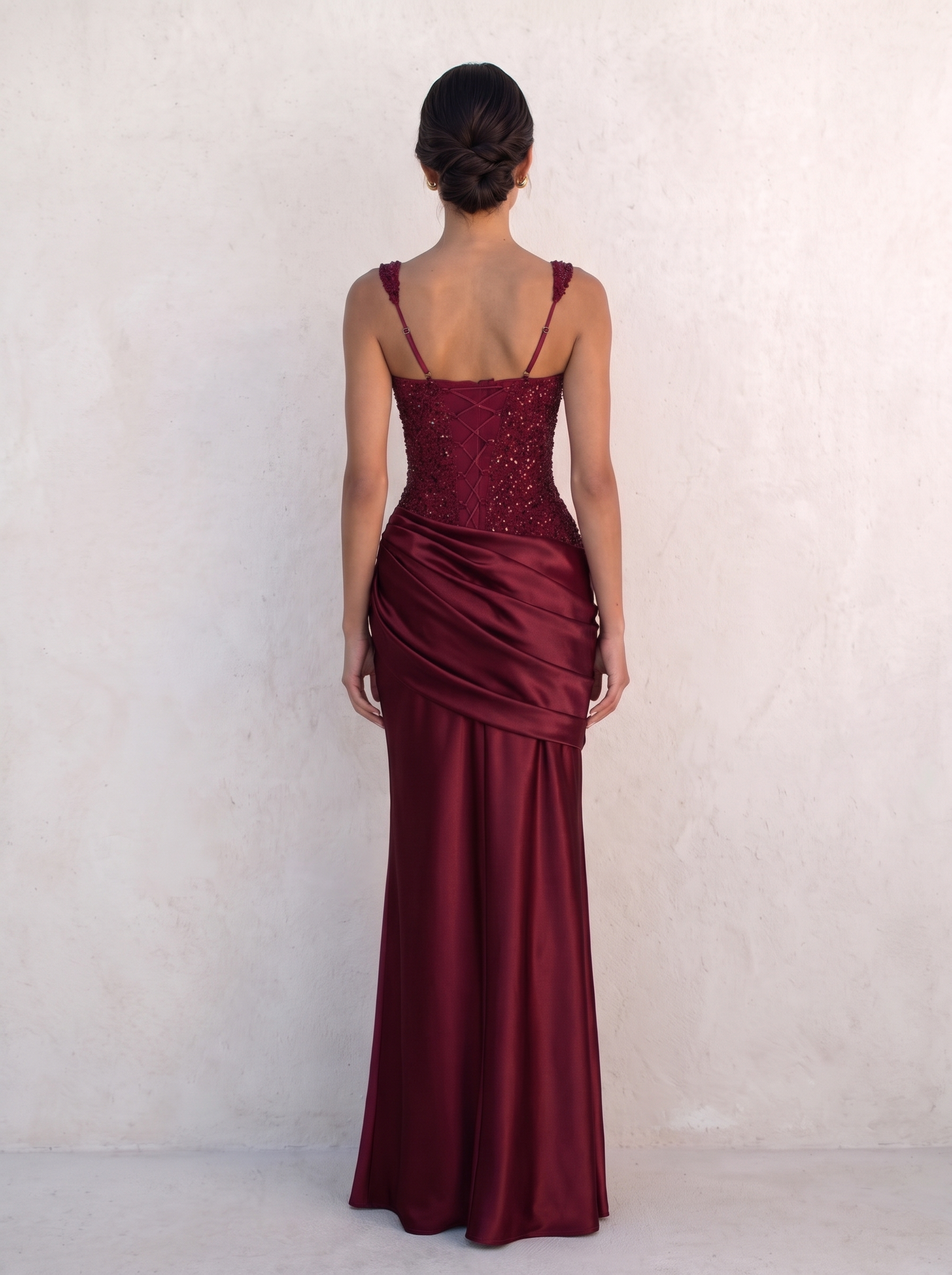 Back of the VESPERA BEADED GOWN in burgundy — criss-cross ribbon lacing over the satin centre panel with beaded panels either side — Kalii