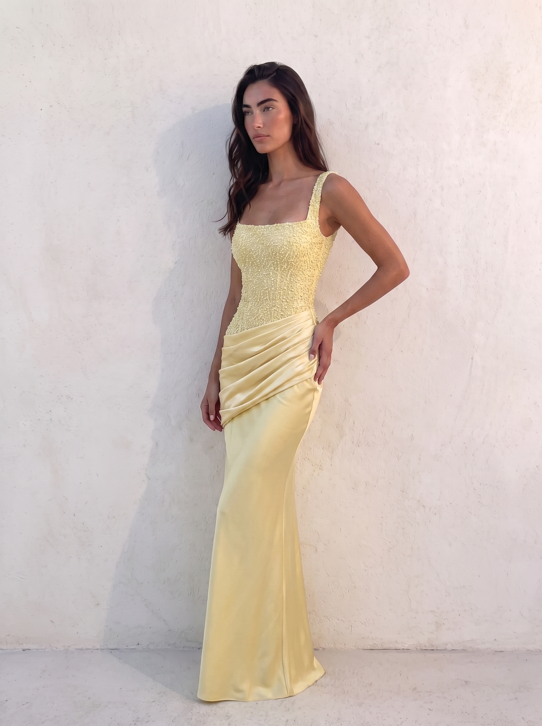 VESPERA BEADED GOWN in lemon — three-quarter view showing the asymmetric pleated hip drape — Kalii